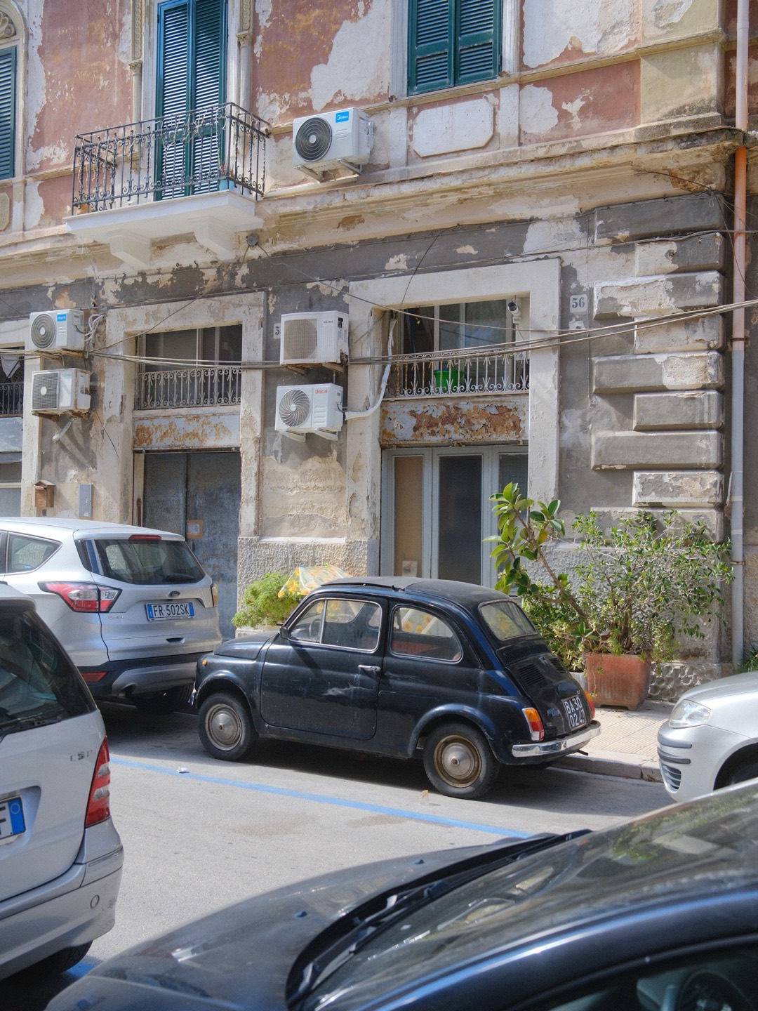 Alter Fiat 500 vor einer Hausfassade