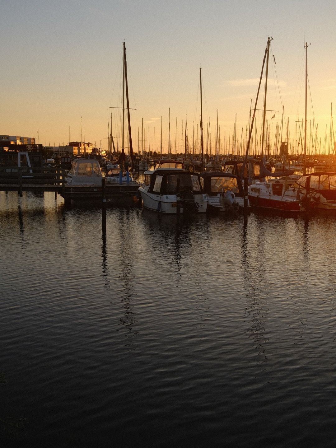 Segelboote im Hafen bei Sonnenuntergang, Spiegelungen im Wasser