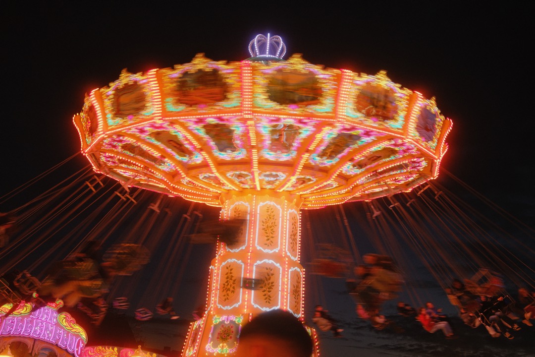 Leuchtendes Kettenkarussell bei Nacht